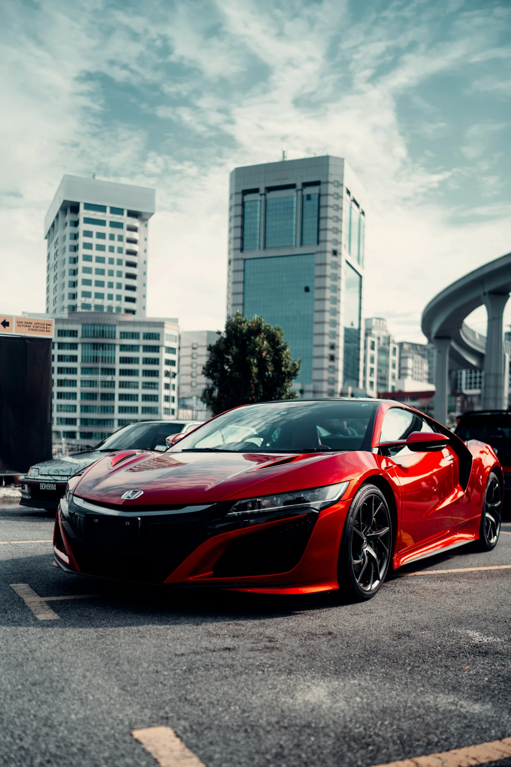 Acura Certified Collision Repair In Jamestown NY Red Acura sports car parked in an urban setting with buildings nearby.